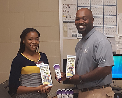 Presenting the Director of Public Works for the City of Clinton with sunscreen lotion and skin and sun safety brochures.
